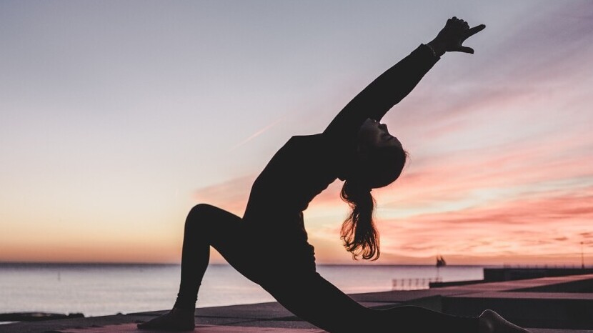 Woman Doing Yoga at Sunset Beach